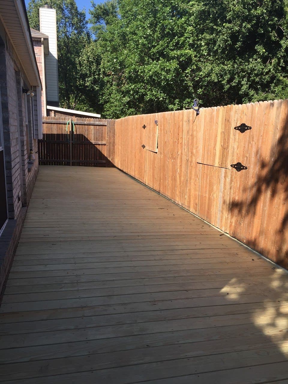 Long deck walkway running alongside a cedar privacy fence