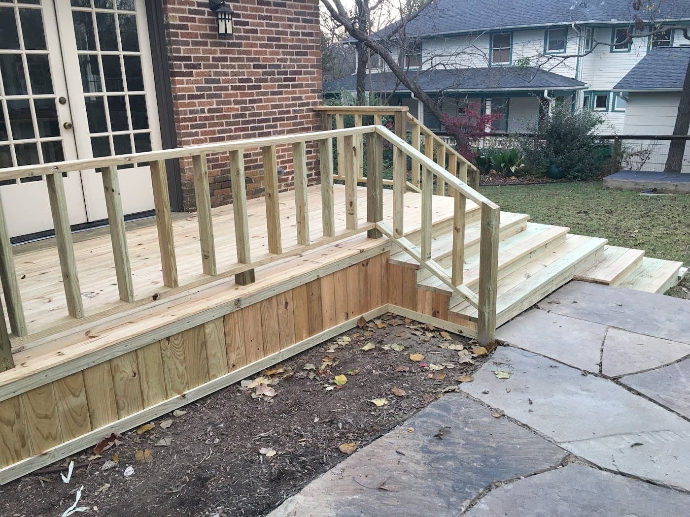 Deck with a railed ramp down to a stone patio