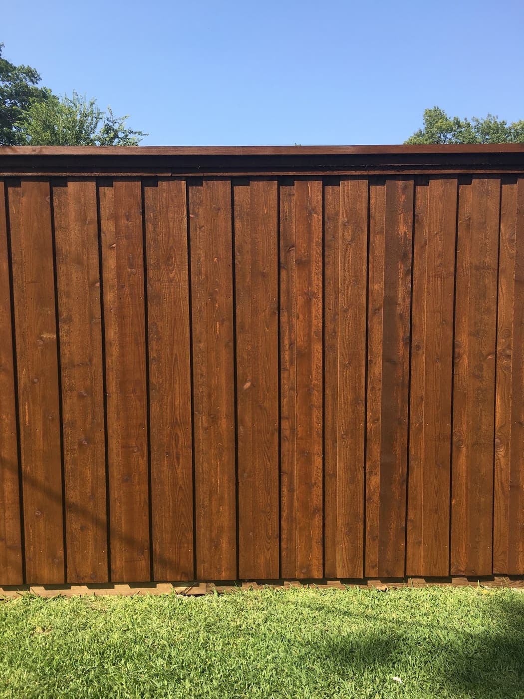Board-on-board cedar fence finished in a dark semi-transparent stain