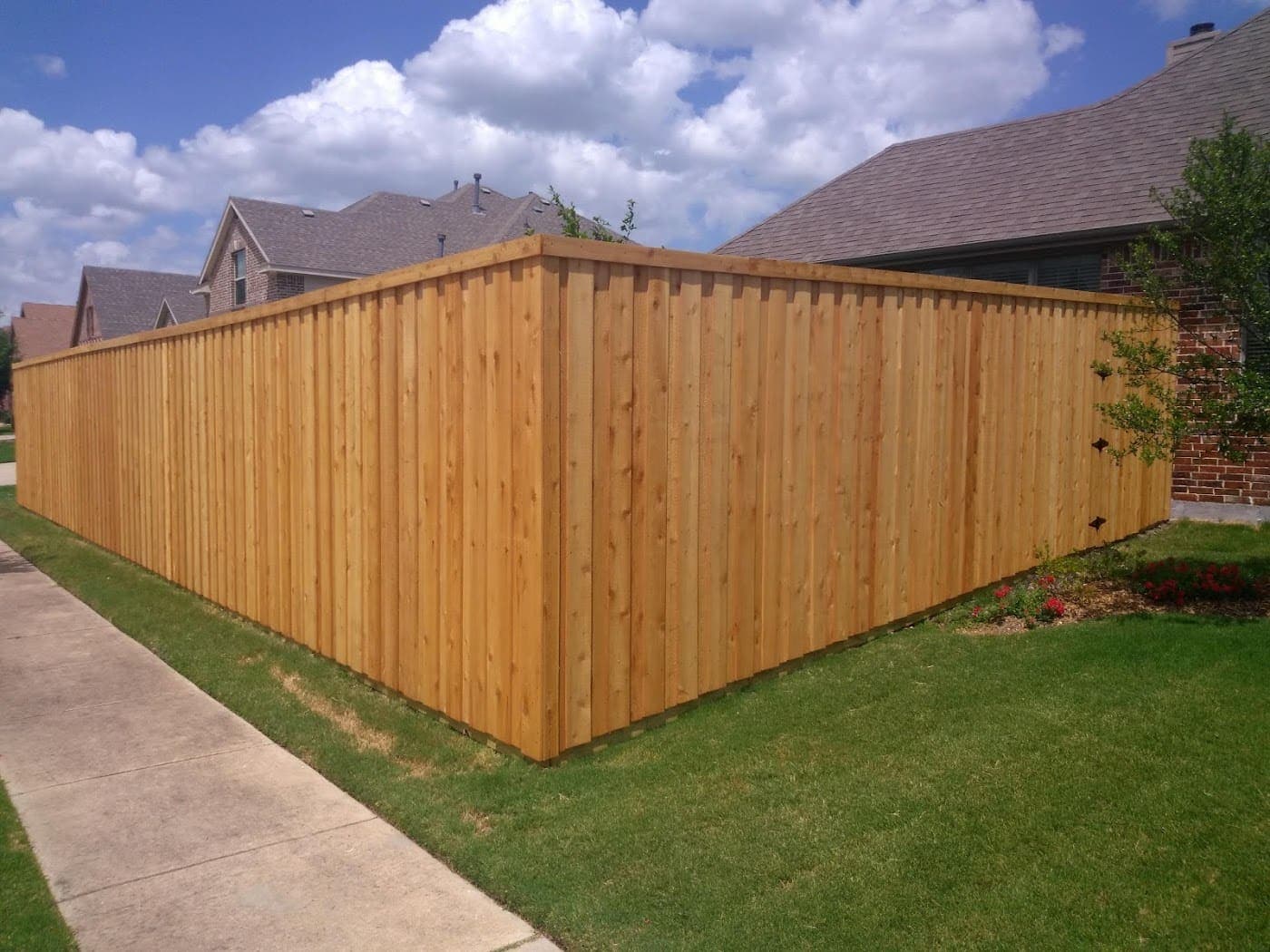 New cedar board-on-board fence, unstained, wrapping a corner lot