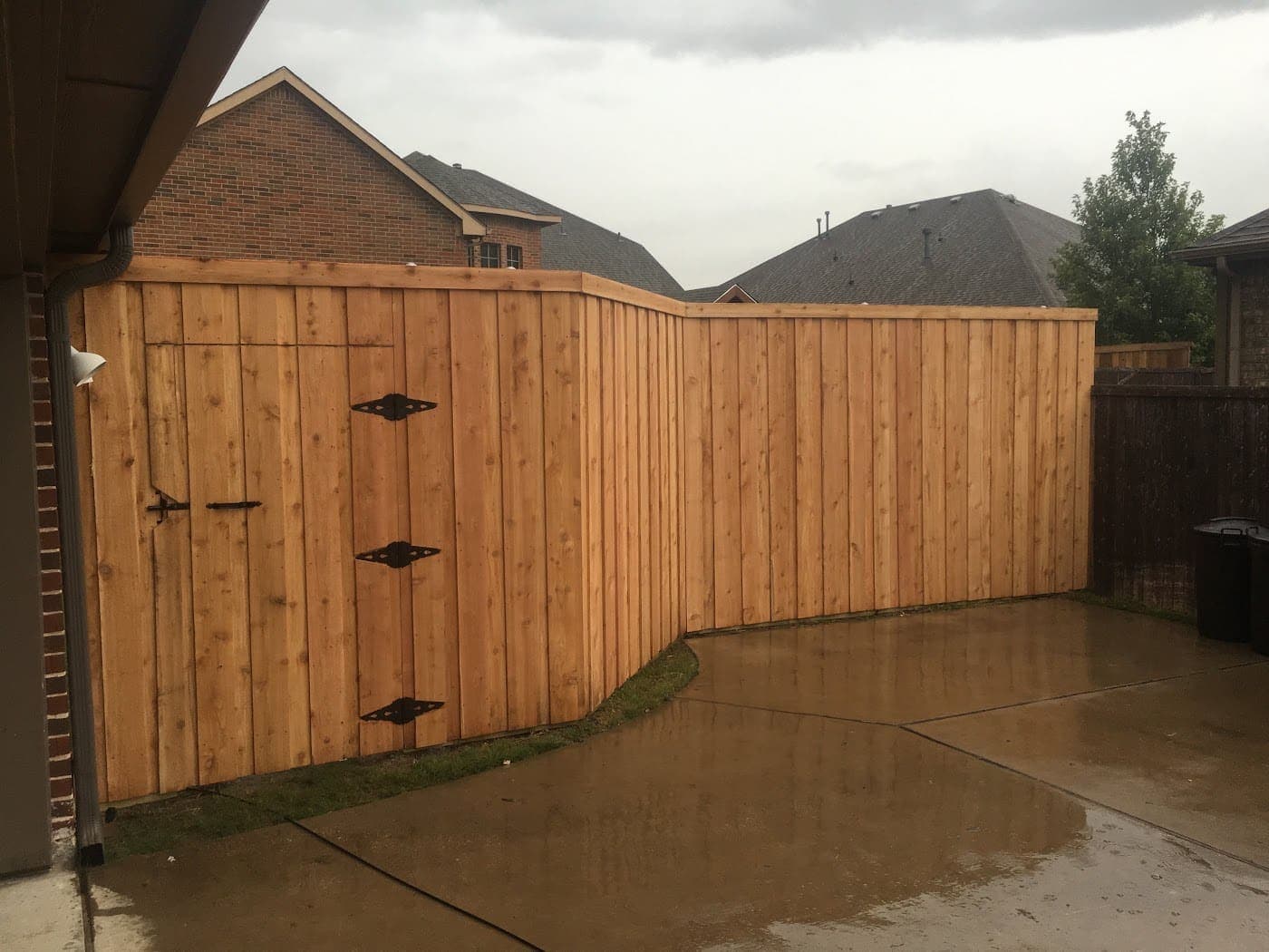 Stained cedar fence with matching gates off a driveway