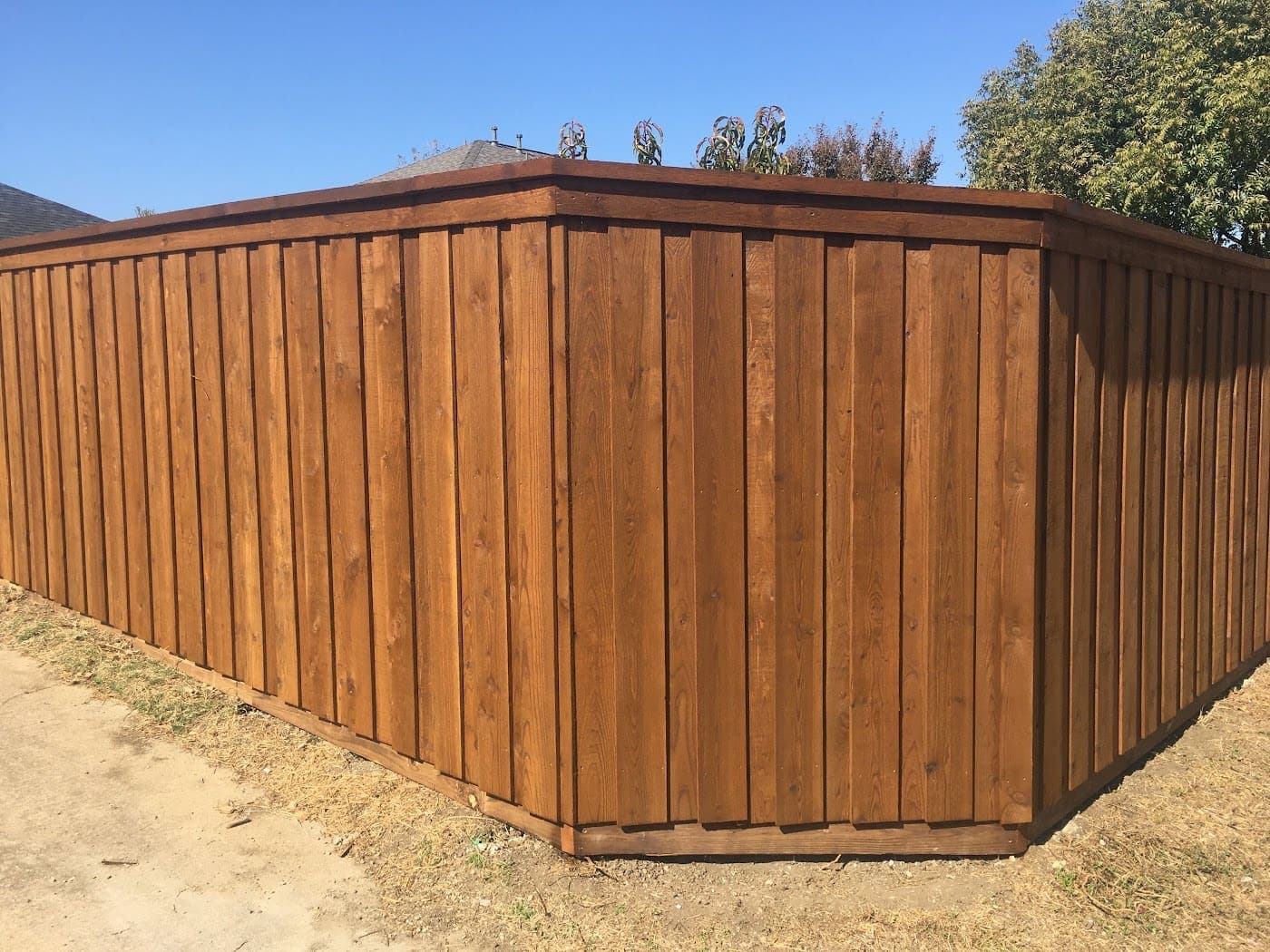 Stained board-on-board cedar fence with full cap at a corner