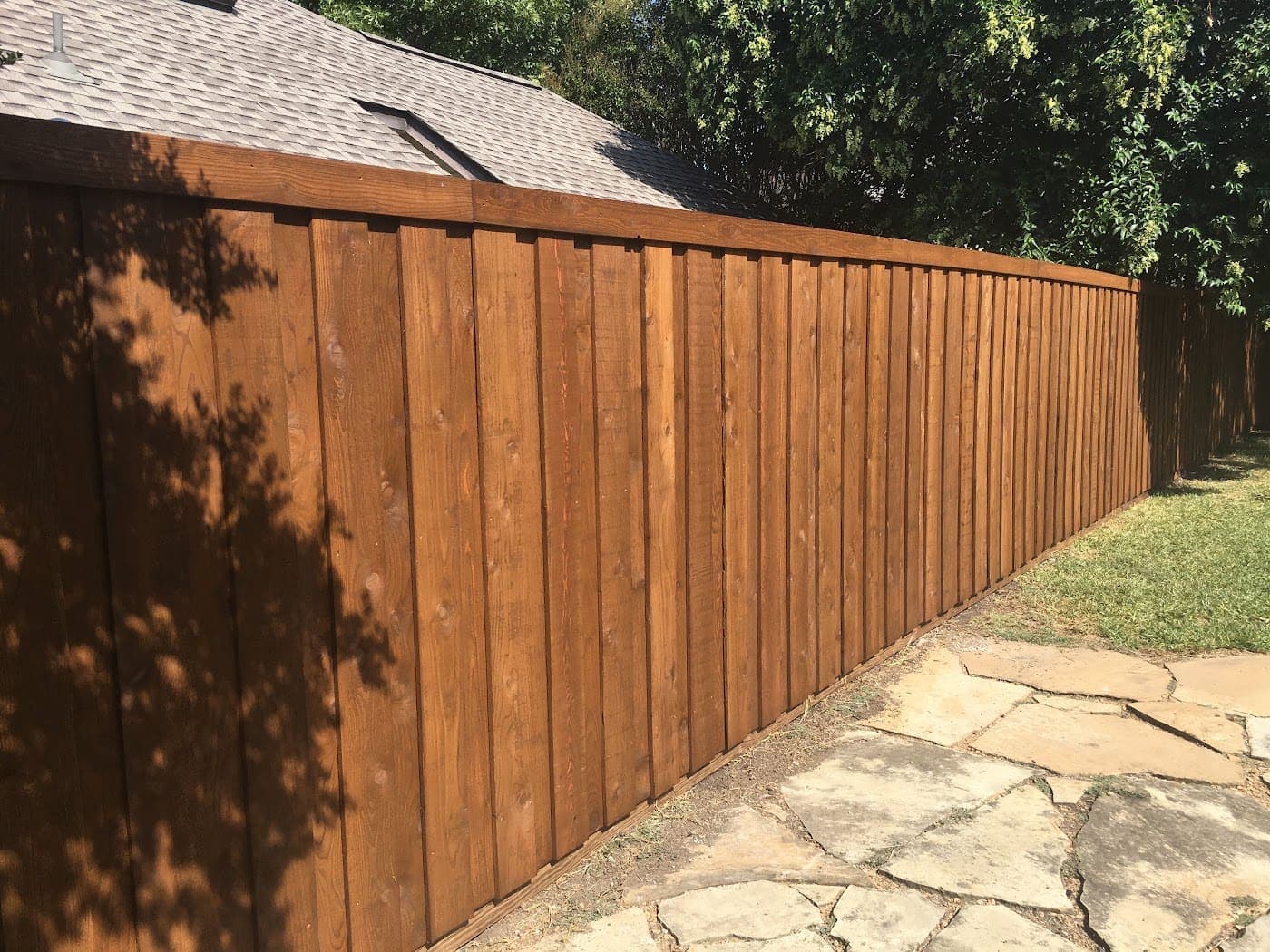 Cedar board-on-board fence beside a flagstone walk