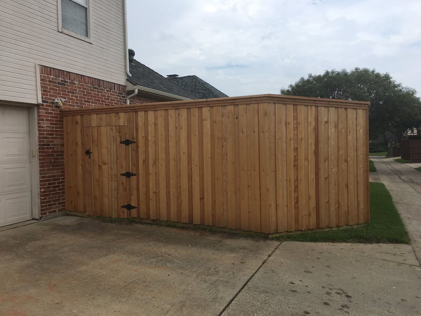 Cedar double drive gate with black hardware and three hinges per leaf