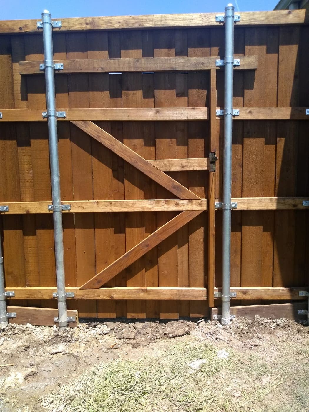 Braced cedar double gate hung on 13-gauge heavy-duty steel posts