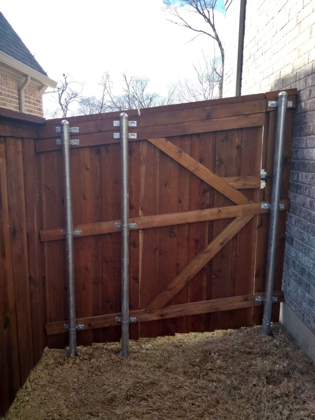 Stained cedar double gate, braced, on steel posts