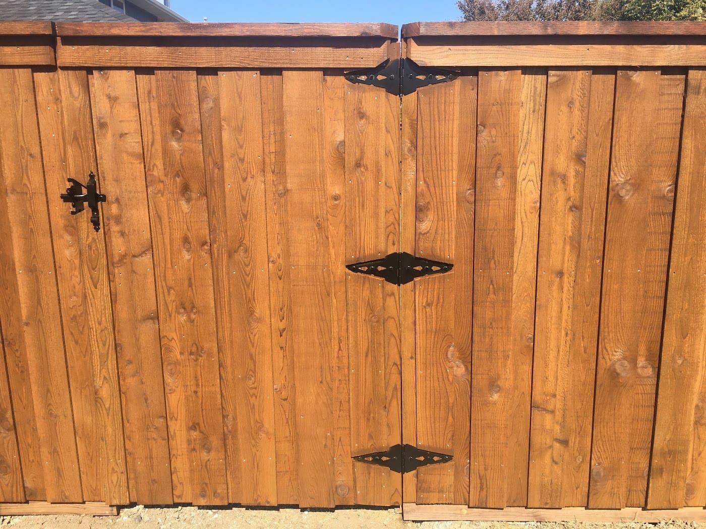 Cedar gate with three black hinges and a heavy-duty latch