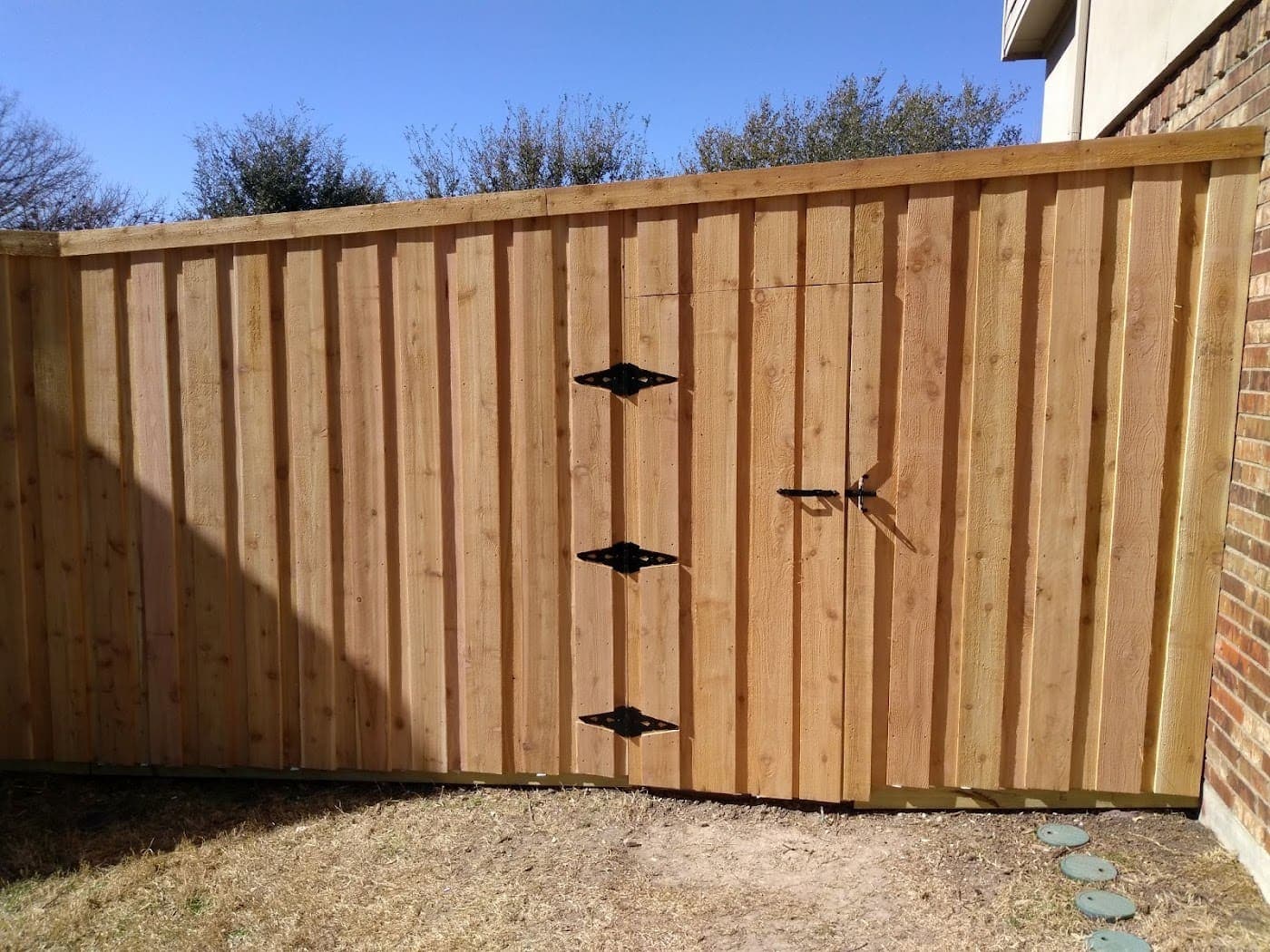 Cedar double gate with black hardware set into a privacy fence