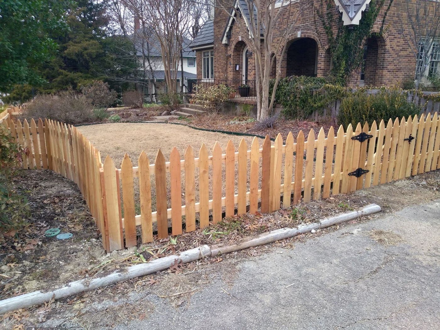Cedar picket fence across a front yard