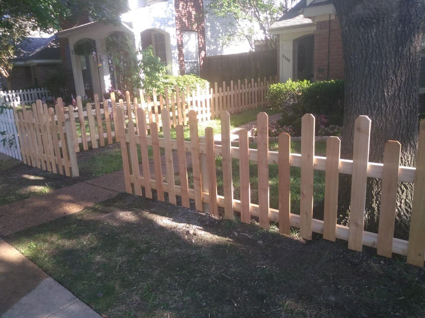 Short cedar picket fence around a garden bed