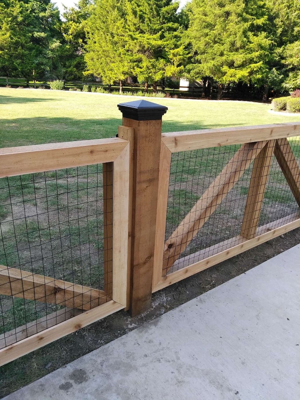 Cedar-frame wire fence with post caps — custom wood and metal build