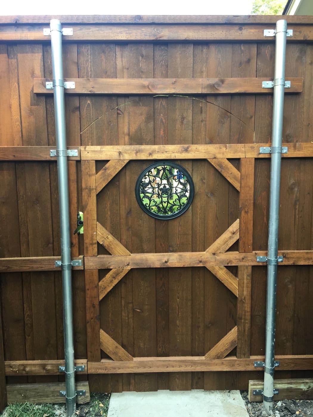 Custom cedar gate with a stained glass insert, on steel posts