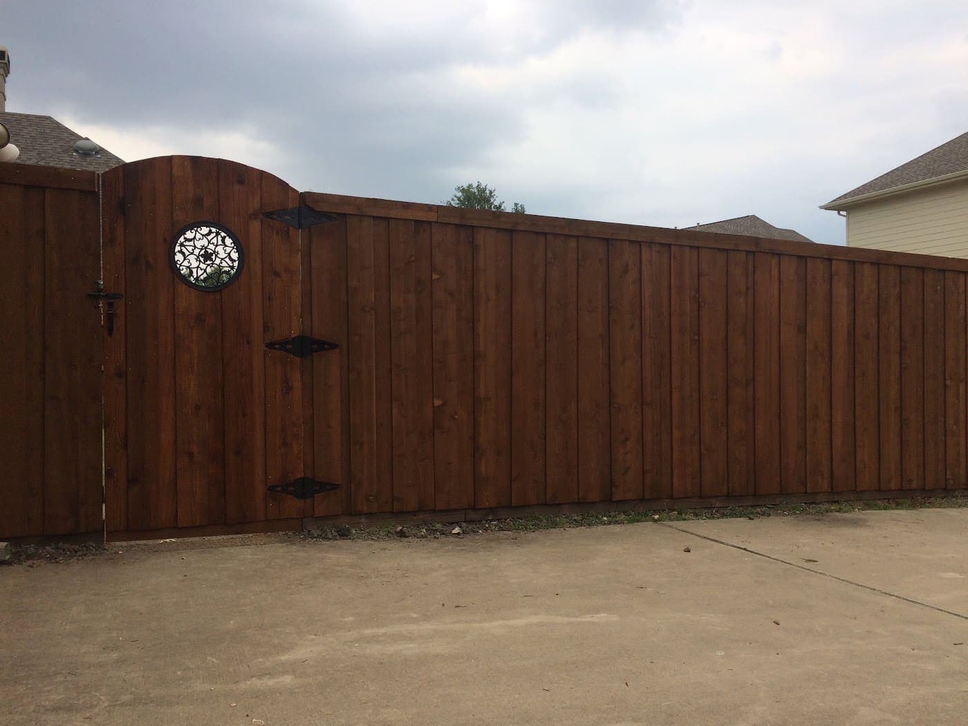 Arched cedar gate with a round decorative window