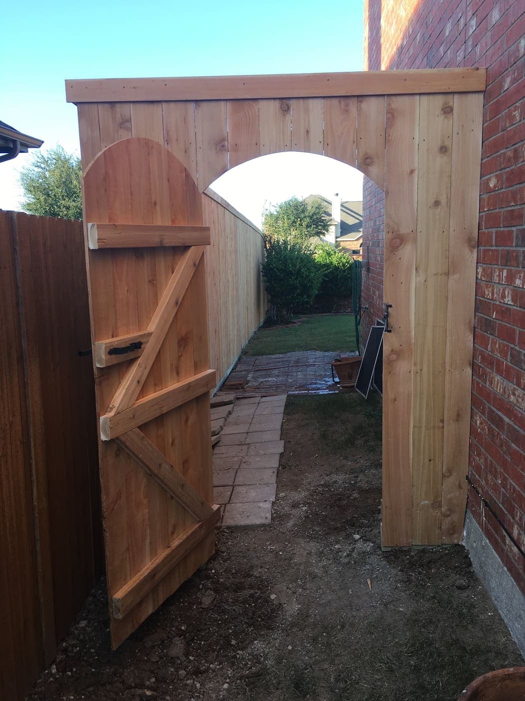 Cedar arbor over a gate opening between two yards