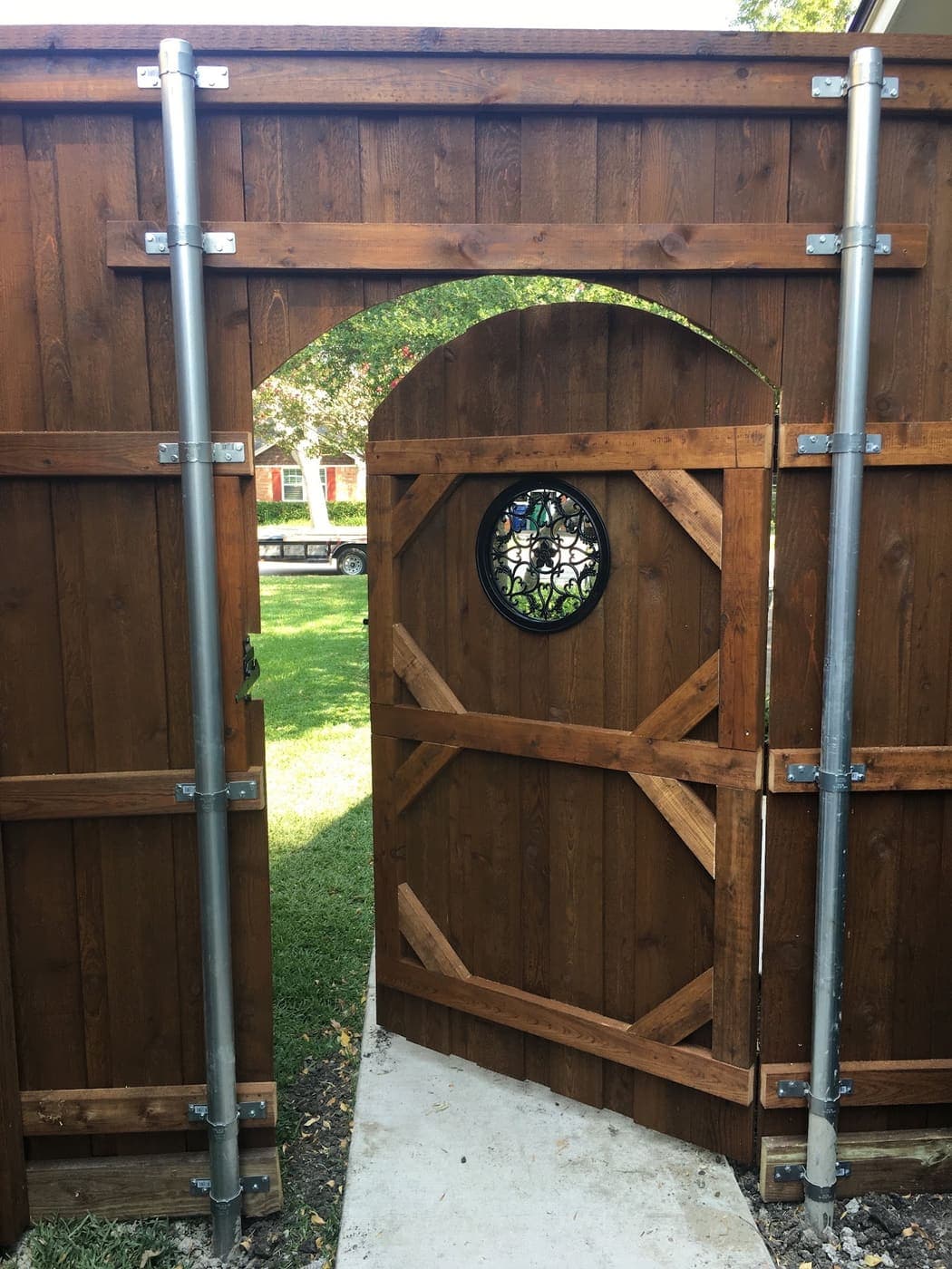 Cedar arbor gate with a round stained glass window