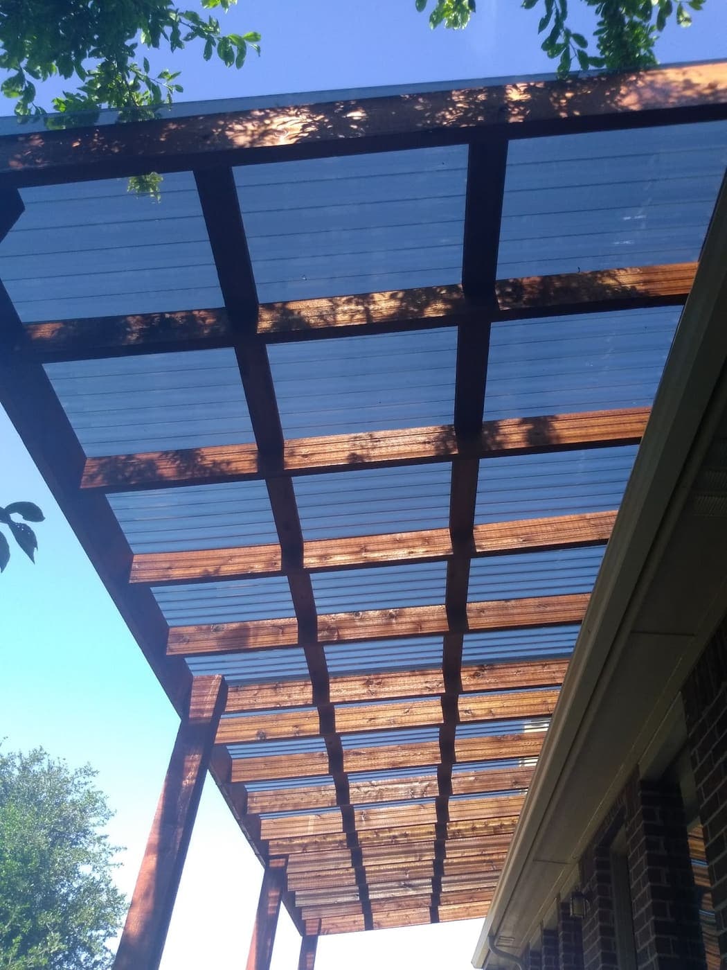 Looking up through a cedar patio cover with roofing panels