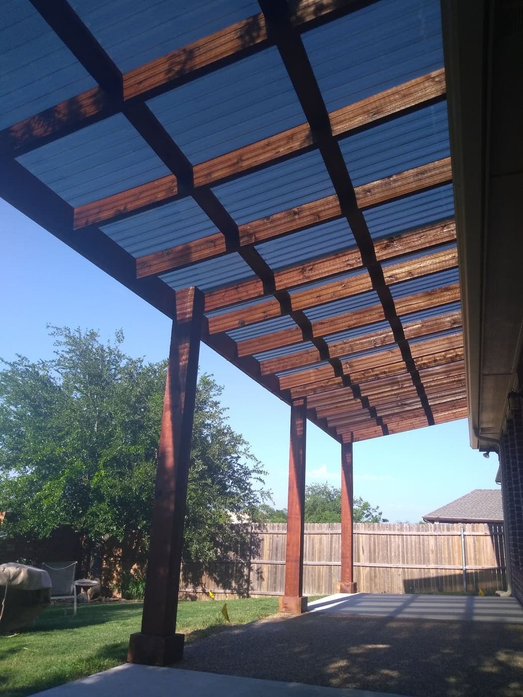 Cedar patio cover on posts over an open patio